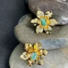 Natural-Essence-earrings-crafted-in-18k-gold-plated-bronze-with-a-young-emerald-at-the-center